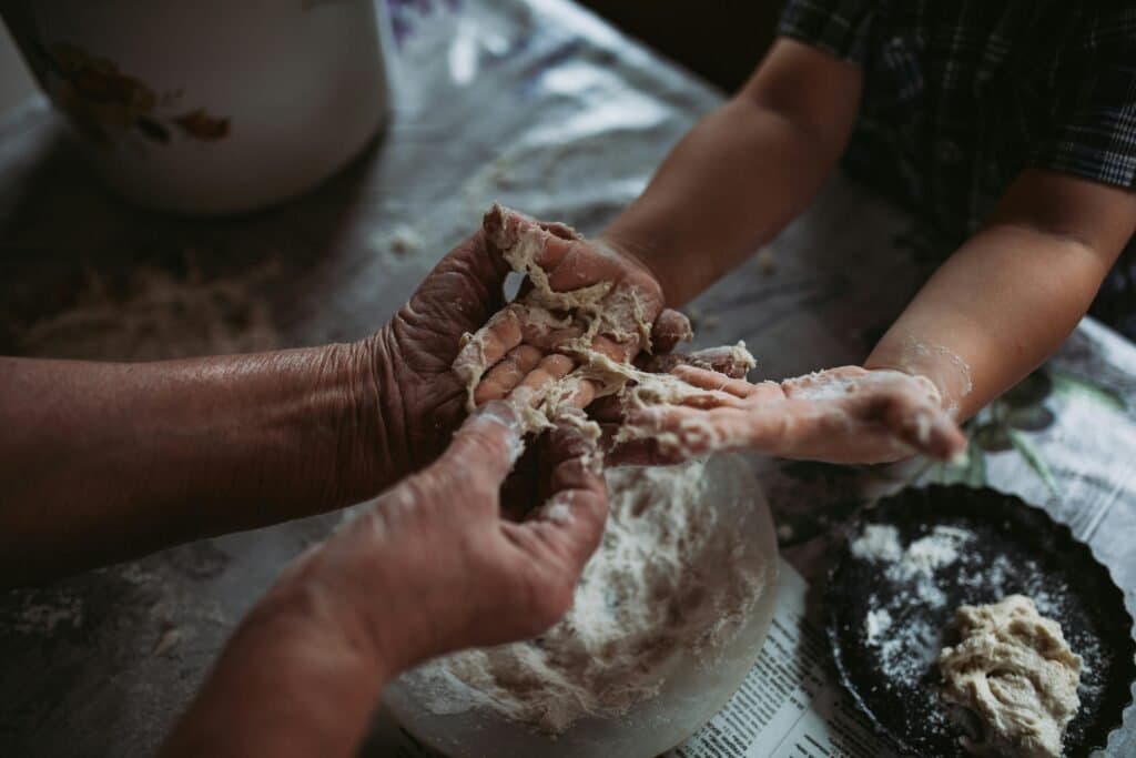 A child's hands learn to knead dough for an easy bread recipe for kids.