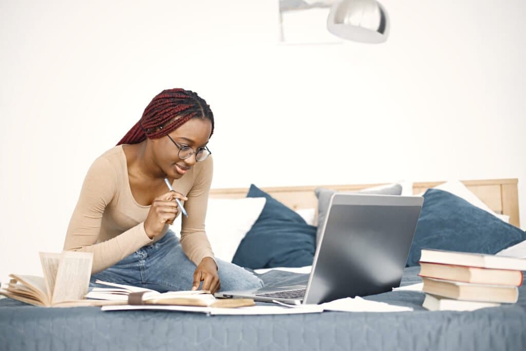 A-student-sitting-in-a-library-focused-on-studying-books-spread-out-on-a-table